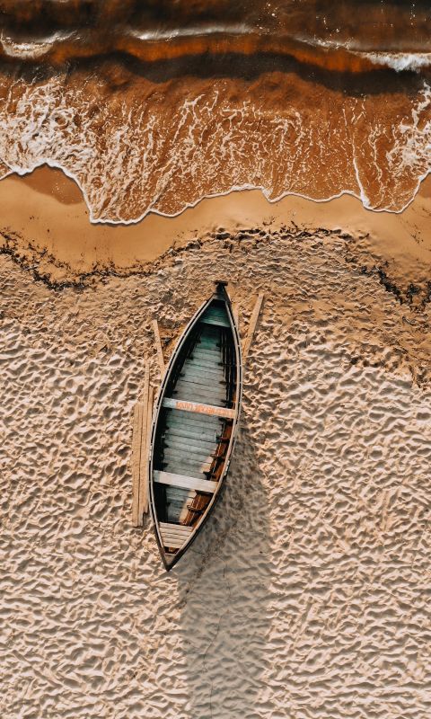 brown and white boat on brown sand wallpaper
