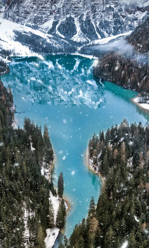 aerial photo of snow covered mountain near body of... wallpaper