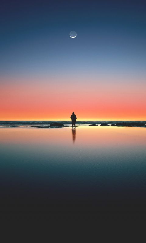 silhouette of man standing on seashore wallpaper