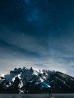 person standing on rock at night wallpaper