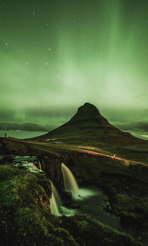 waterfalls near mountain taken under green sky wallpaper