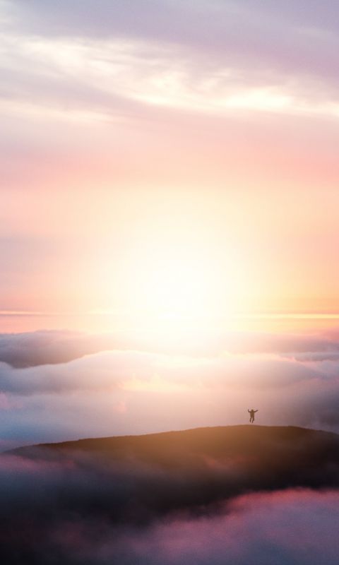 man jumping on hill during golden hour wallpaper