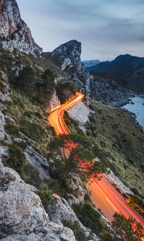 road beside a cliff near body of water during dayt... wallpaper