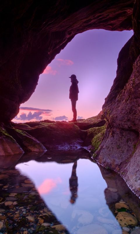 man standing in front of cave wallpaper