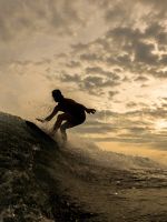 silhouette of person riding on surfboard wallpaper