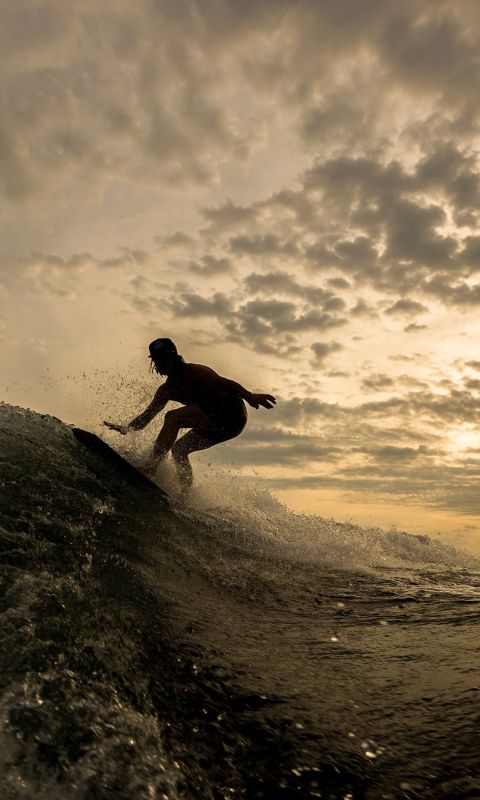 silhouette of person riding on surfboard wallpaper