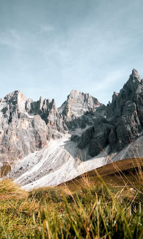 grass field near rock formation wallpaper