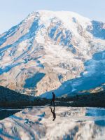man walking near glacier mountain during day wallpaper
