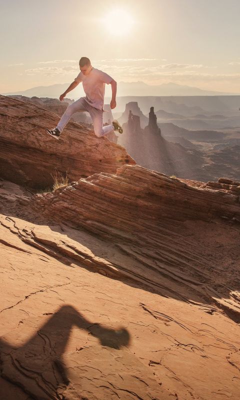 man jumping under sunlight wallpaper