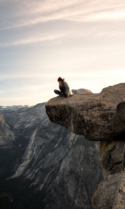 person sitting on brown mountain wallpaper