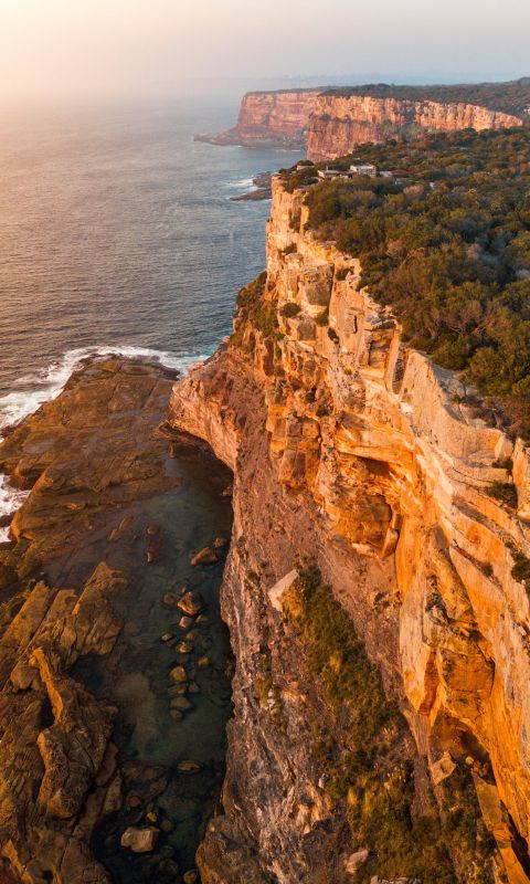 aerial photography of mountain beside sea wallpaper