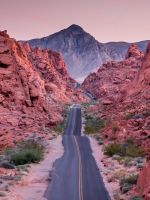 photo of empty road between rock formations wallpaper