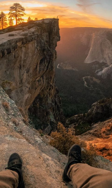 person pair of shoes and sitting on edge of mounta... wallpaper