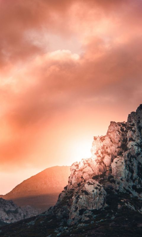 black and gray hill under cloudy sky during sunset wallpaper